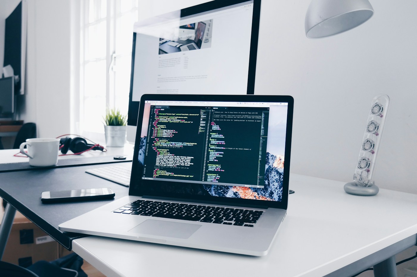A development workspace with a laptop displaying code